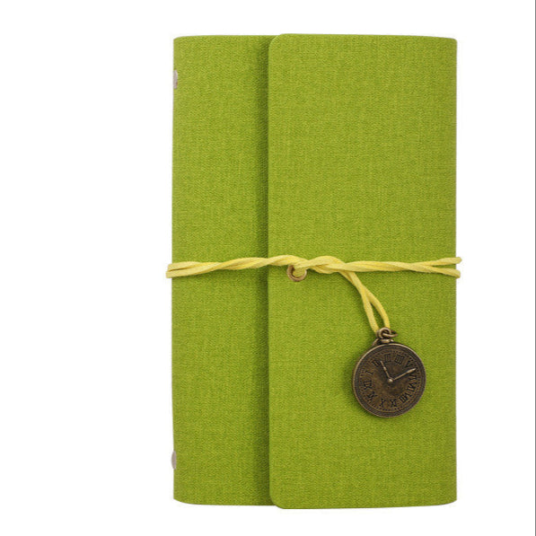Green PU leather notebook with a decorative charm on a white background
