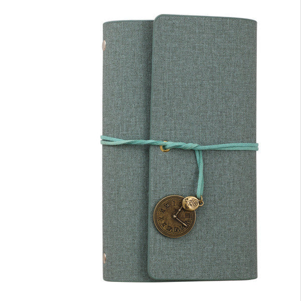Green PU leather notebook with string closure and decorative charm on a white background