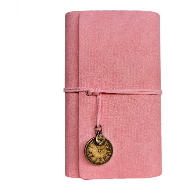 Pink PU leather notebook with a charm on a white background