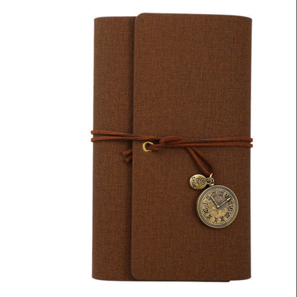 Brown PU leather bound notebook with a decorative charm on a white background
